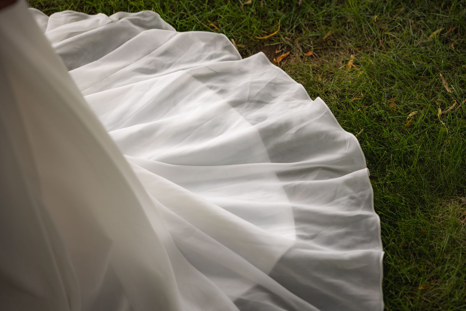The flowing train of an ivory bridal gown