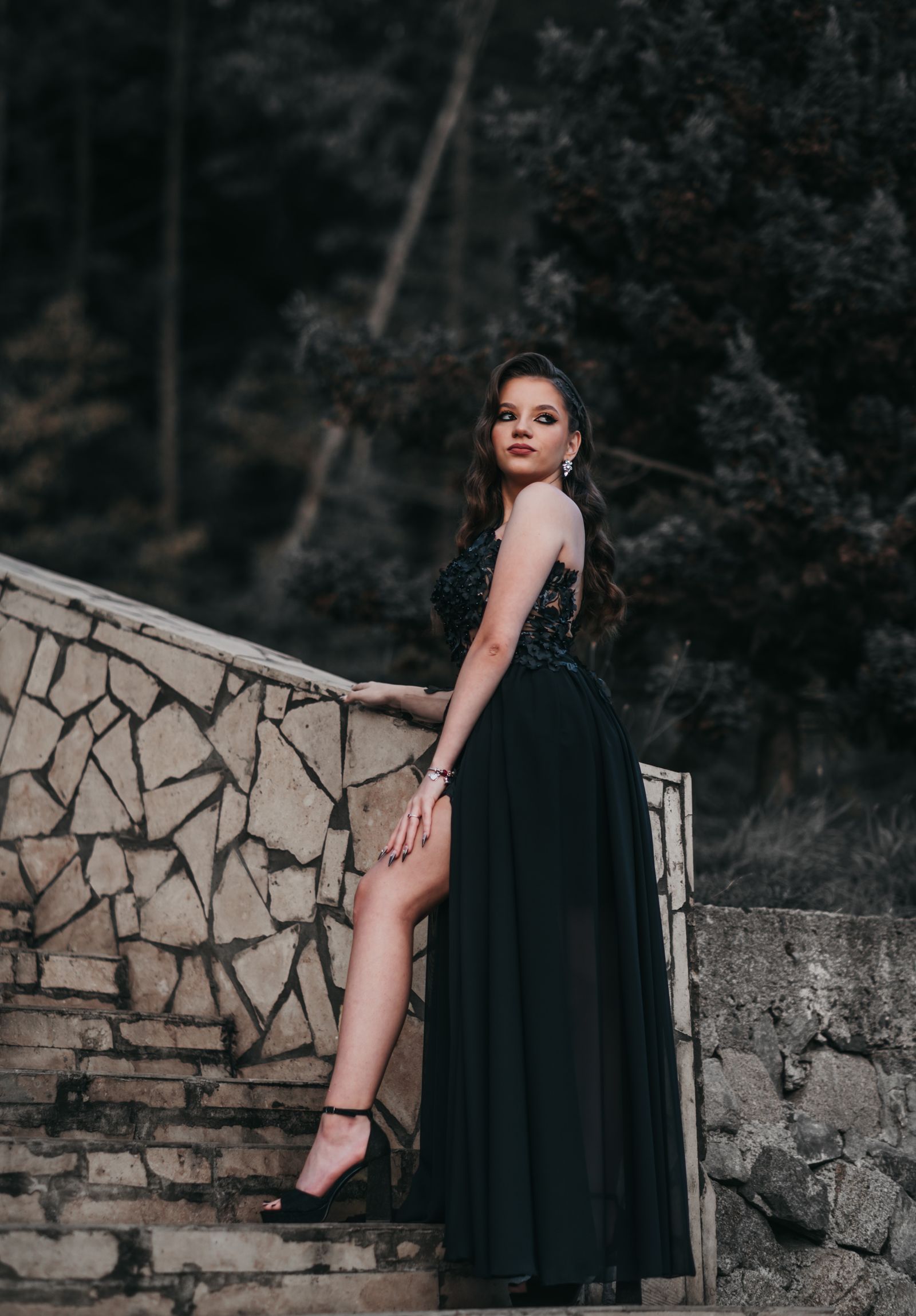 A black lace floor-length prom gown with a high slit